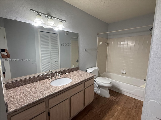 3705SW 27 Th St Unit 416, Gainesville, FL 32608 - full bathroom featuring wood finished floors, toilet, a textured wall, vanity, and shower / tub combination