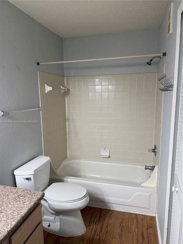 3705SW 27 Th St Unit 416, Gainesville, FL 32608 - full bathroom with vanity, wood finished floors, toilet, bathing tub / shower combination, and a textured ceiling
