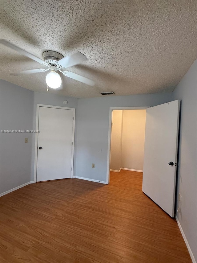 3705SW 27 Th St Unit 416, Gainesville, FL 32608 - unfurnished bedroom with wood finished floors, baseboards, a textured ceiling, and ceiling fan