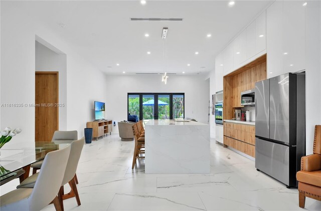 1902 Della Dr, Naples, FL 34117 - kitchen featuring stainless steel appliances, modern cabinets, white cabinets, a kitchen island with sink, and recessed lighting