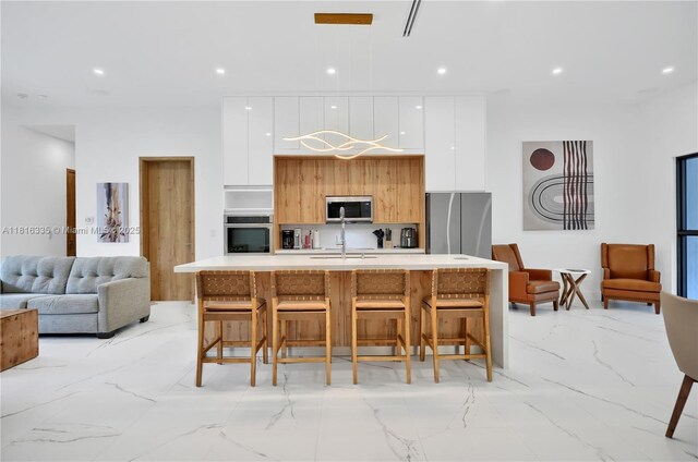 1902 Della Dr, Naples, FL 34117 - kitchen with appliances with stainless steel finishes, modern cabinets, light marble finish floors, white cabinetry, and light countertops