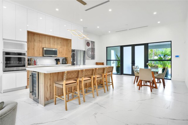 1902 Della Dr, Naples, FL 34117 - kitchen with appliances with stainless steel finishes, modern cabinets, a sink, french doors, and white cabinets