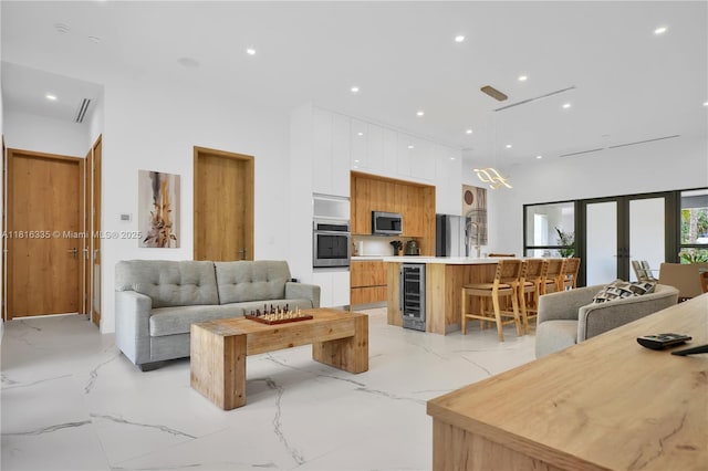 1902 Della Dr, Naples, FL 34117 - living room with light marble finish flooring, wine cooler, french doors, and recessed lighting