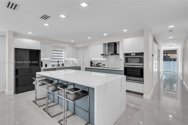 1045 Hollywood Blvd, Hollywood, FL 33019 - kitchen with modern cabinets, wall chimney range hood, black appliances, a sink, and recessed lighting