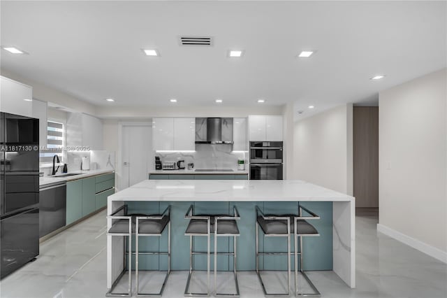 1045 Hollywood Blvd, Hollywood, FL 33019 - kitchen featuring modern cabinets, wall chimney range hood, multiple ovens, stainless steel dishwasher, and white cabinets