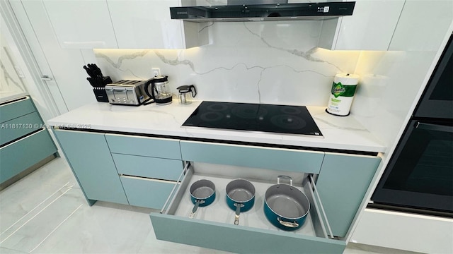 1045 Hollywood Blvd, Hollywood, FL 33019 - kitchen view of black electric stovetop, ventilation hood, backsplash, and modern cabinets