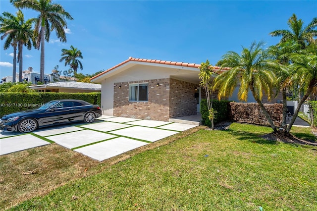 1045 Hollywood Blvd, Hollywood, FL 33019 - view of front facade with brick siding, a tiled roof, and a front lawn