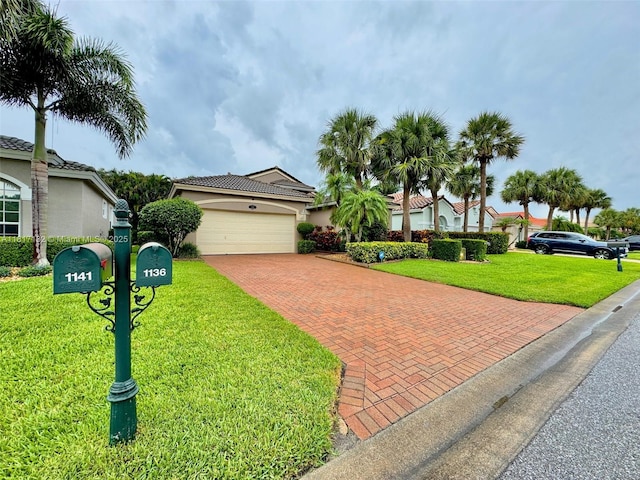 1136 SE Westminster Pl, Stuart, FL 34997 - view of front of house featuring decorative driveway, a garage, a front yard, and stucco siding