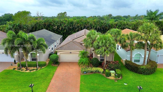 1136 SE Westminster Pl, Stuart, FL 34997 - view of front of house featuring an attached garage, decorative driveway, stucco siding, and a front yard