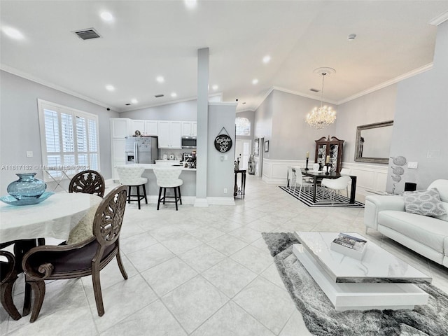 1136 SE Westminster Pl, Stuart, FL 34997 - living area featuring ornamental molding, vaulted ceiling, a chandelier, light tile patterned floors, and wainscoting