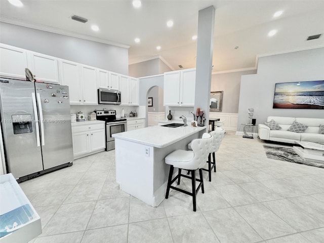 1136 SE Westminster Pl, Stuart, FL 34997 - kitchen featuring stainless steel appliances, ornamental molding, a kitchen bar, light tile patterned flooring, and a sink