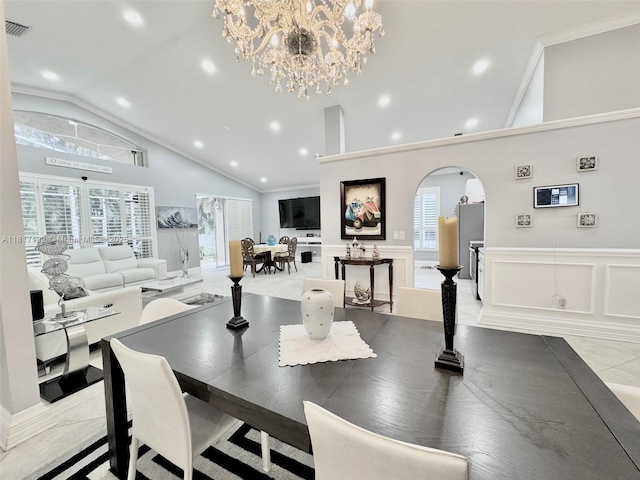 1136 SE Westminster Pl, Stuart, FL 34997 - dining room featuring a decorative wall, arched walkways, lofted ceiling, a chandelier, and wainscoting