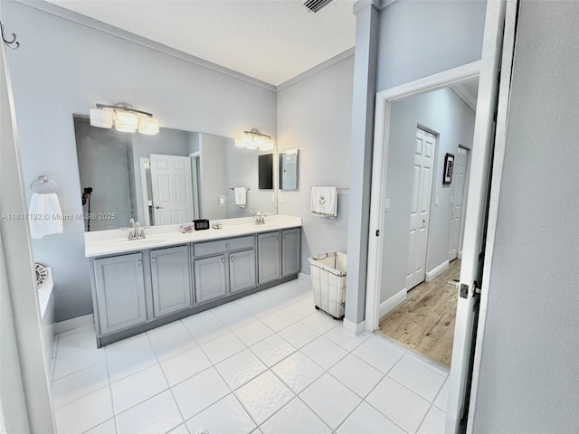 1136 SE Westminster Pl, Stuart, FL 34997 - bathroom featuring double vanity, a bath, baseboards, and tile patterned flooring