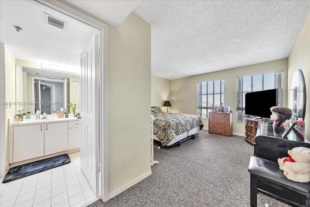 2351 Douglas Rd Unit 1204, Miami, FL 33145 - bedroom featuring a sink, baseboards, ensuite bath, a textured ceiling, and light carpet