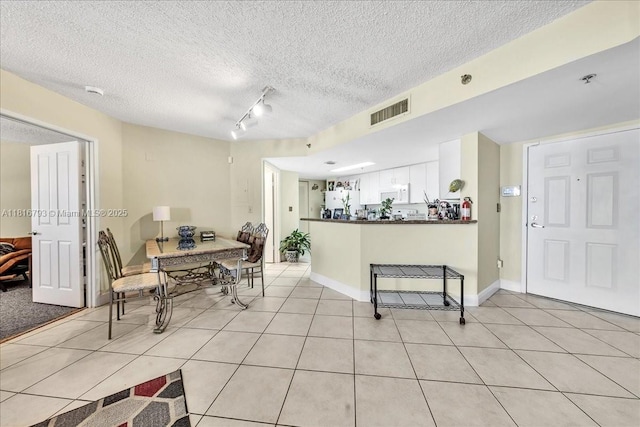 2351 Douglas Rd Unit 1204, Miami, FL 33145 - dining area featuring light tile patterned floors, a textured ceiling, and track lighting