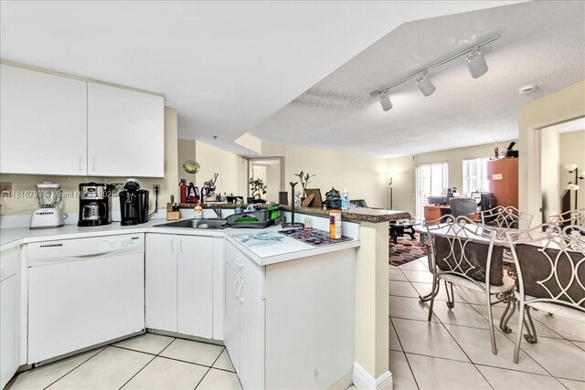 2351 Douglas Rd Unit 1204, Miami, FL 33145 - kitchen with white dishwasher, a peninsula, light tile patterned flooring, open floor plan, and a textured ceiling