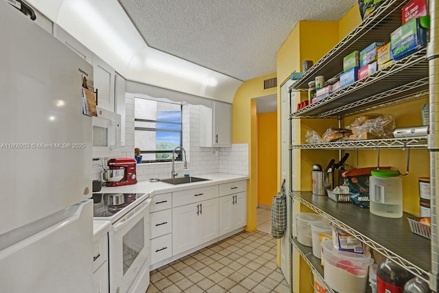 6555 W Broward Blvd Unit 412, Plantation, FL 33317 - kitchen featuring white appliances, tasteful backsplash, white cabinetry, light tile patterned floors, and light countertops