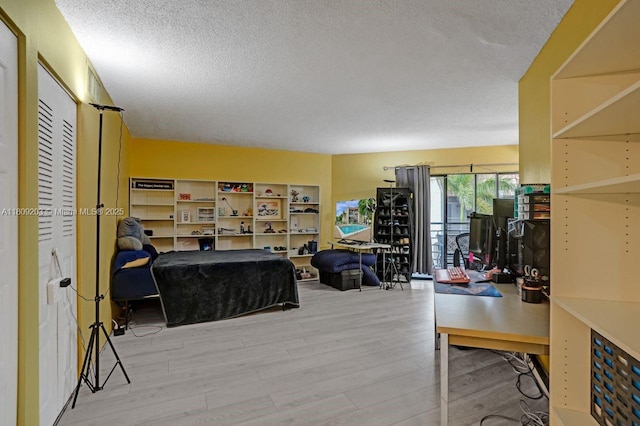 6555 W Broward Blvd Unit 412, Plantation, FL 33317 - living area featuring a textured ceiling, wood finished floors, and a desk