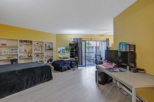 6555 W Broward Blvd Unit 412, Plantation, FL 33317 - bedroom with access to exterior, light wood-style flooring, and a textured ceiling