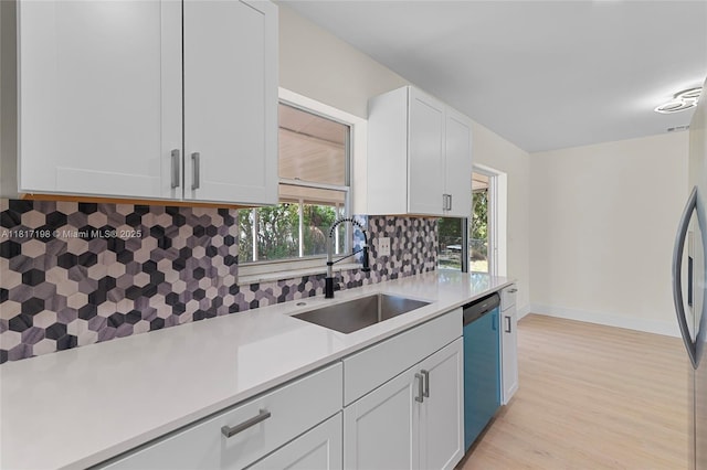 8510 SE Citrus Way, Hobe Sound, FL 33455 - kitchen with a sink, dishwashing machine, light countertops, white cabinetry, and tasteful backsplash