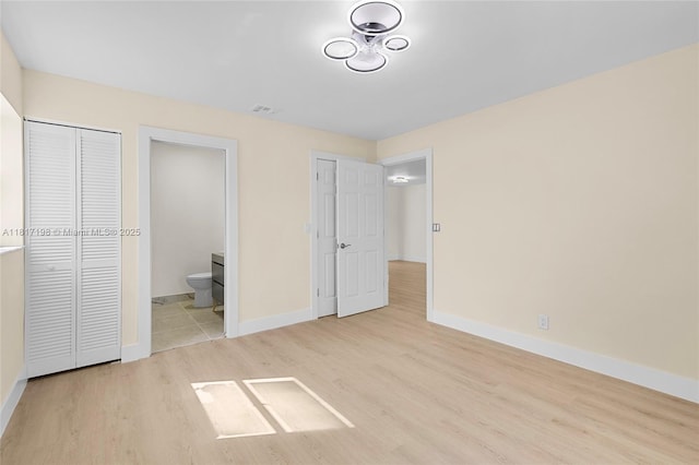 8510 SE Citrus Way, Hobe Sound, FL 33455 - unfurnished bedroom featuring wood finished floors, baseboards, and ensuite bath
