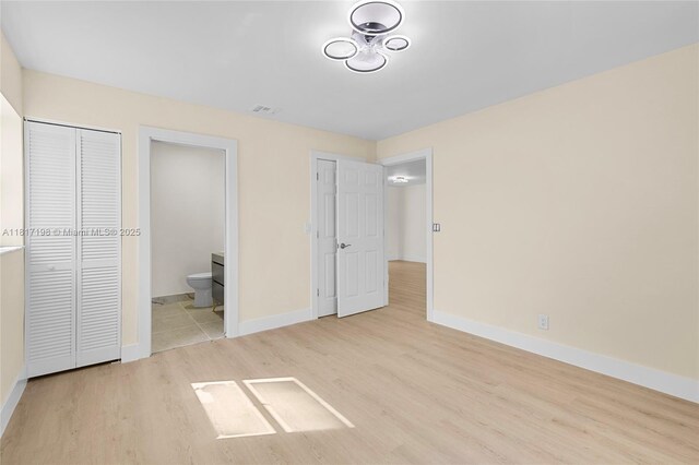 8510 SE Citrus Way, Hobe Sound, FL 33455 - unfurnished bedroom featuring wood finished floors, baseboards, and ensuite bath
