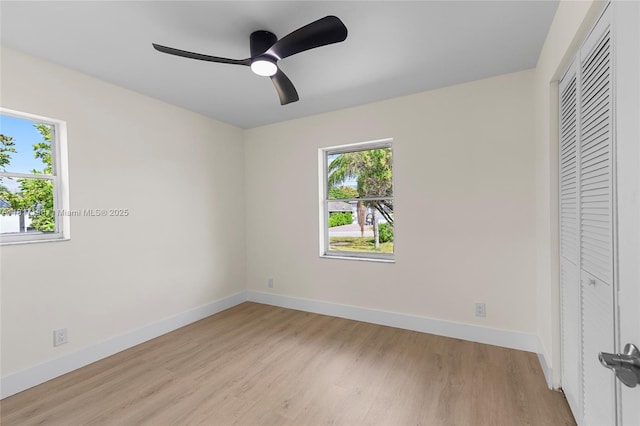 8510 SE Citrus Way, Hobe Sound, FL 33455 - unfurnished bedroom featuring multiple windows, light wood-style floors, and baseboards