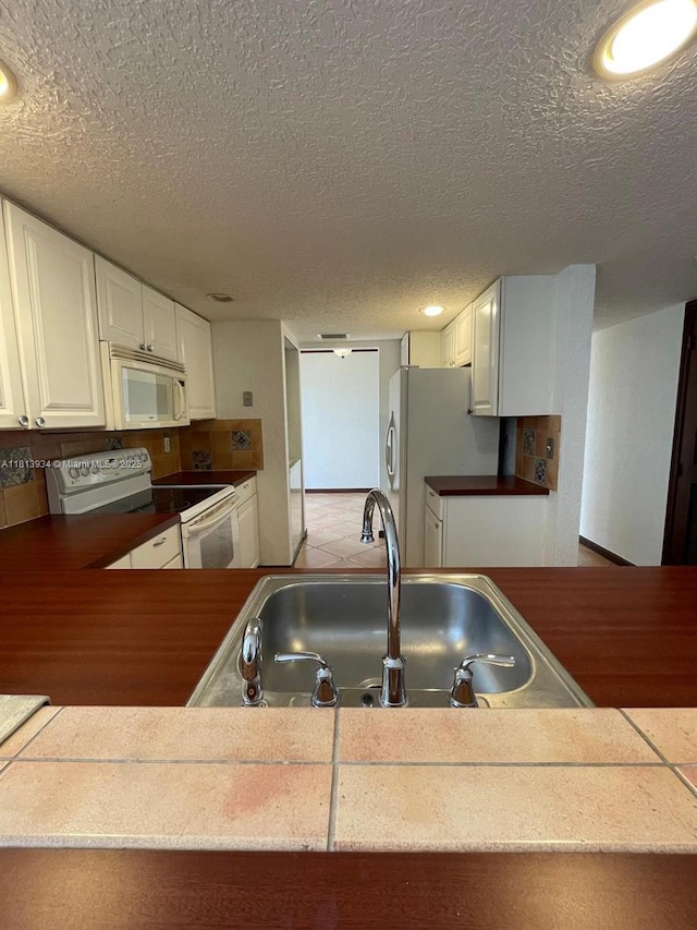 6575 W Oakland Park Blvd Unit 511, Lauderhill, FL 33313 - kitchen with white appliances, a sink, a textured ceiling, recessed lighting, and white cabinetry