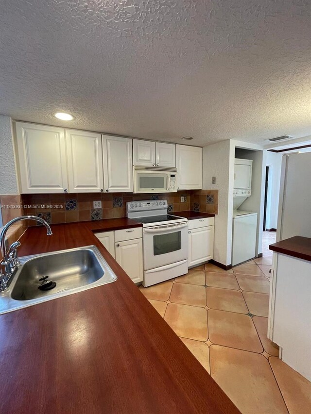 6575 W Oakland Park Blvd Unit 511, Lauderhill, FL 33313 - kitchen with white appliances, stacked washer / drying machine, a sink, dark countertops, and a textured ceiling