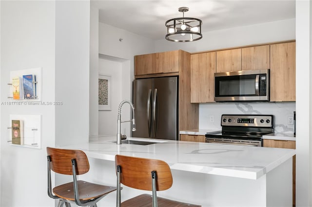 1900 Van Buren St Unit 407B, Hollywood, FL 33020 - kitchen with stainless steel appliances, a kitchen breakfast bar, light stone counters, modern cabinets, and a peninsula