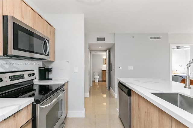 1900 Van Buren St Unit 407B, Hollywood, FL 33020 - kitchen with appliances with stainless steel finishes, light stone counters, light brown cabinets, and light marble finish floors