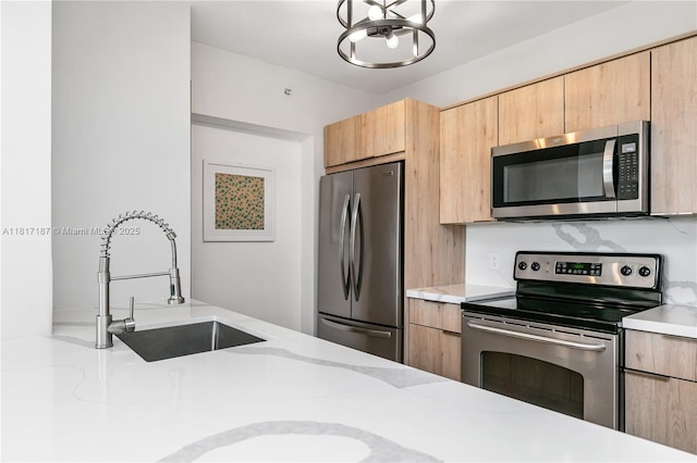 1900 Van Buren St Unit 407B, Hollywood, FL 33020 - kitchen with stainless steel appliances, light brown cabinets, a chandelier, and modern cabinets