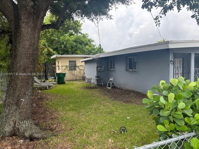 248 NW 69th St, Miami, FL 33150 - rear view of property with stucco siding and a lawn
