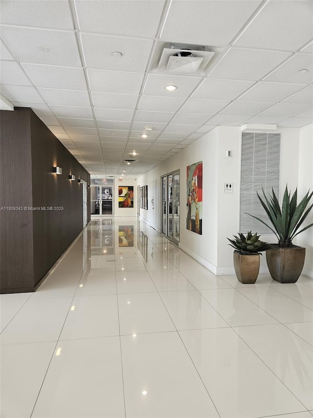 5701 E Collins Ave Unit Ph10, Miami Beach, FL 33140 - hallway with light tile patterned flooring, a drop ceiling, and baseboards
