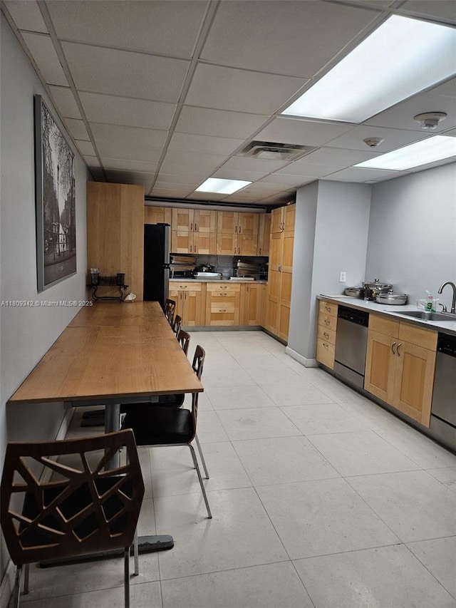 5701 E Collins Ave Unit Ph10, Miami Beach, FL 33140 - kitchen with stainless steel appliances, a sink, a paneled ceiling, light tile patterned floors, and wood walls