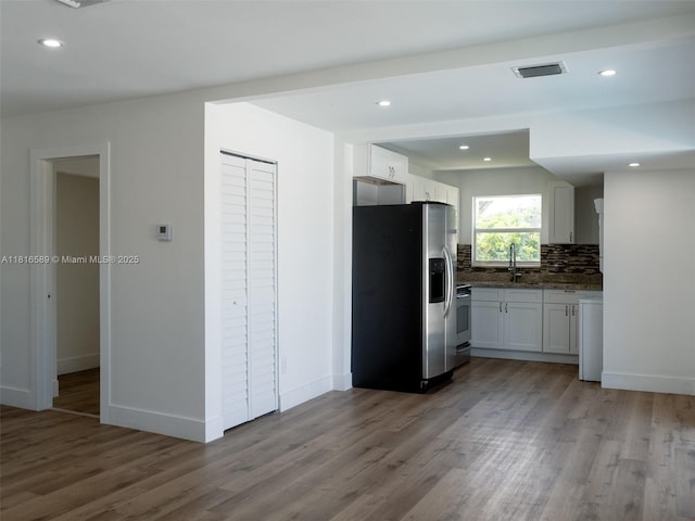 3613 SW 12th Pl, Fort Lauderdale, FL 33312 - kitchen featuring stainless steel fridge, wood finished floors, backsplash, white cabinets, and recessed lighting