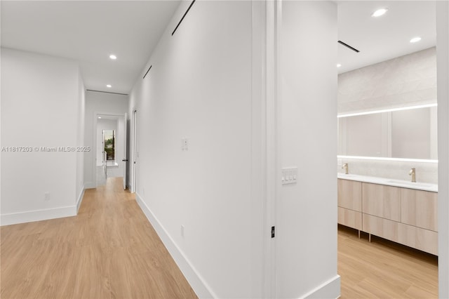 8811 SW 56th St, Miami, FL 33165 - hallway featuring light wood-type flooring, a sink, recessed lighting, and baseboards