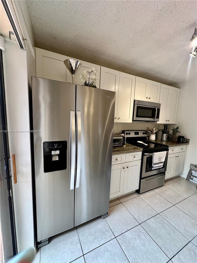 4306 43rd Way, West Palm Beach, FL 33407 - kitchen with appliances with stainless steel finishes, a textured ceiling, white cabinetry, and light tile patterned floors