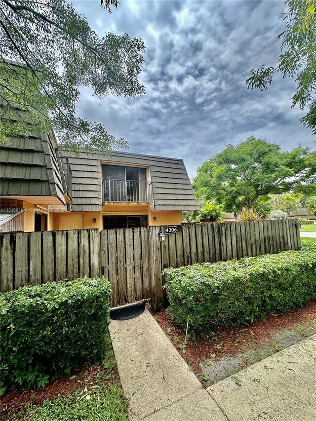 4306 43rd Way, West Palm Beach, FL 33407 - back of house featuring mansard roof and a fenced front yard
