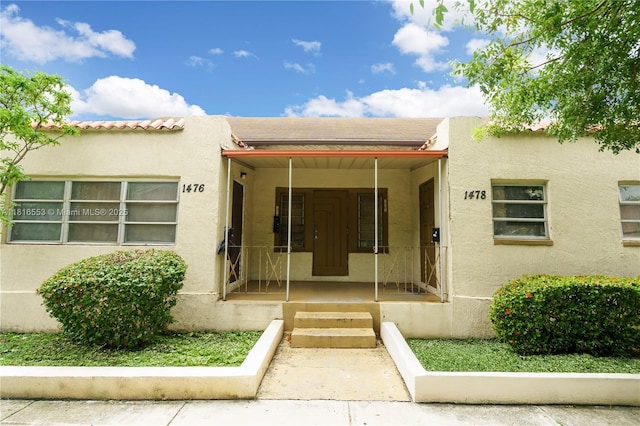1478 SW 2nd St, Miami, FL 33135 - doorway to property featuring stucco siding and covered porch