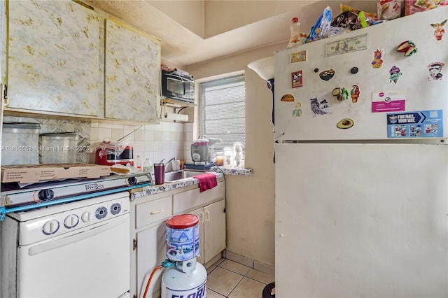 1478 SW 2nd St, Miami, FL 33135 - kitchen featuring freestanding refrigerator, light tile patterned flooring, tasteful backsplash, light countertops, and a sink