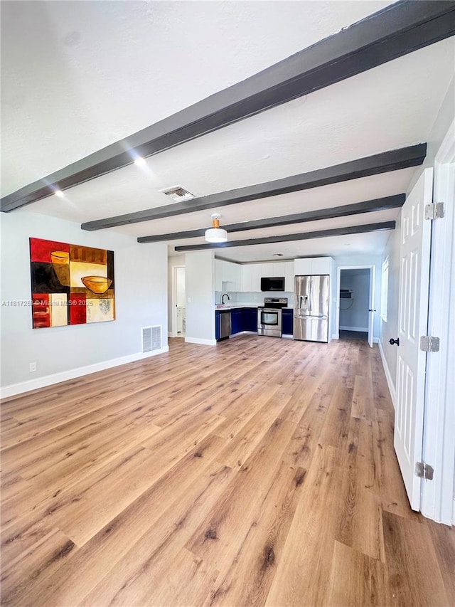 3731 SW 58th Ter, Davie, FL 33314 - unfurnished living room with beam ceiling and light wood-style floors