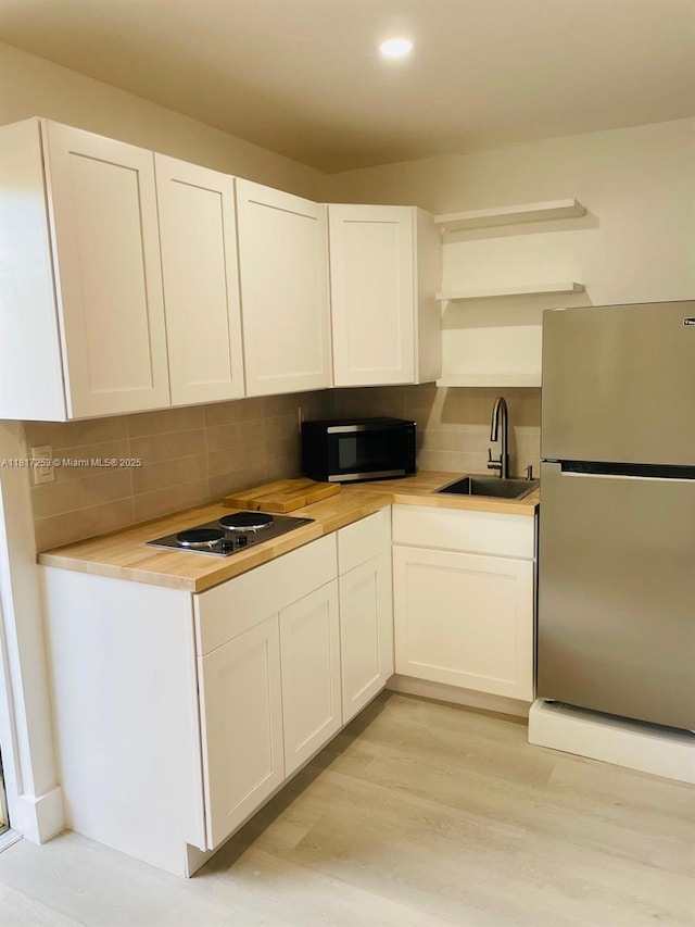 3731 SW 58th Ter, Davie, FL 33314 - kitchen featuring appliances with stainless steel finishes, a sink, backsplash, white cabinets, and light countertops