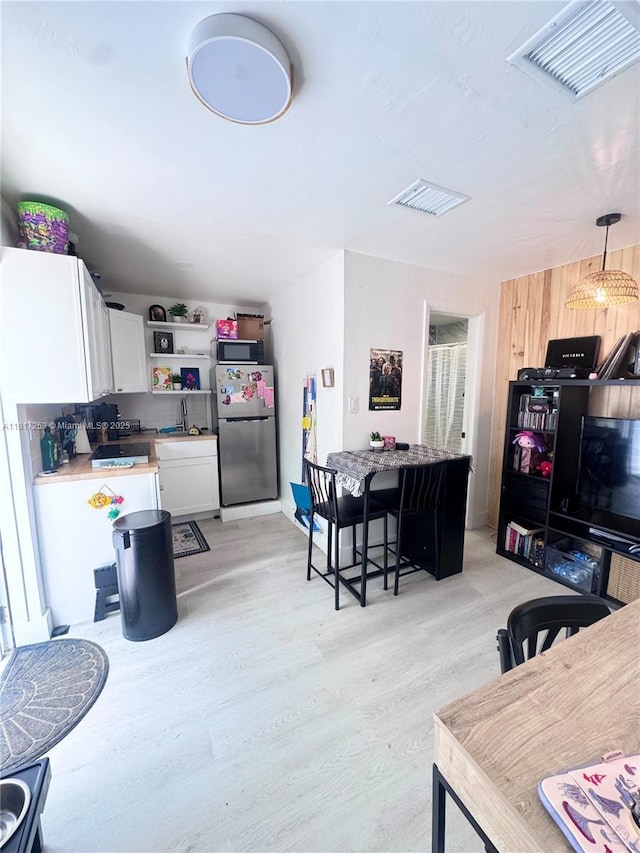 3731 SW 58th Ter, Davie, FL 33314 - kitchen with stainless steel appliances, white cabinets, light wood-style floors, and open shelves