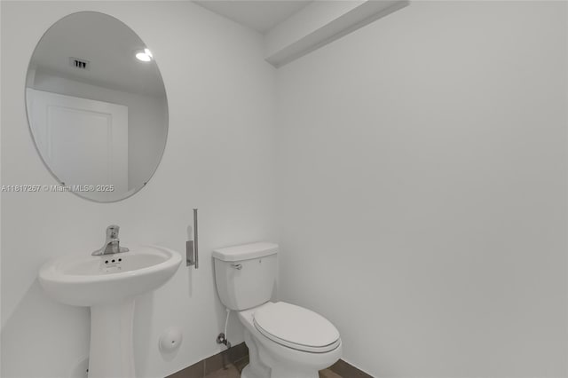 2608 SE 11th Ct Unit 2608, Homestead, FL 33035 - half bathroom featuring toilet, baseboards, wood finished floors, and a sink