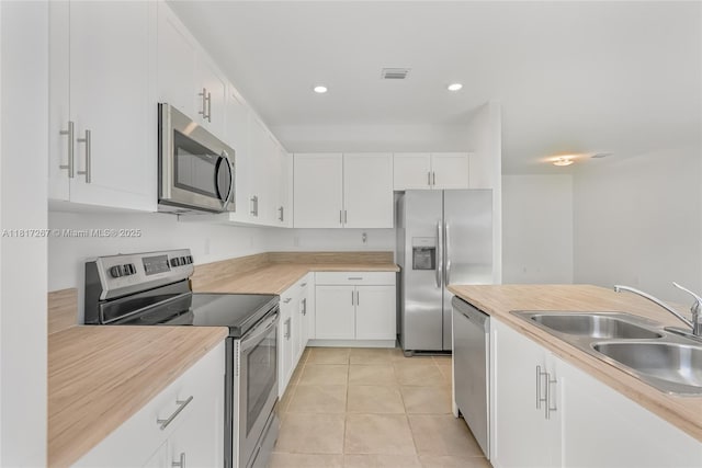 2608 SE 11th Ct Unit 2608, Homestead, FL 33035 - kitchen featuring stainless steel appliances, a sink, white cabinets, light tile patterned floors, and recessed lighting