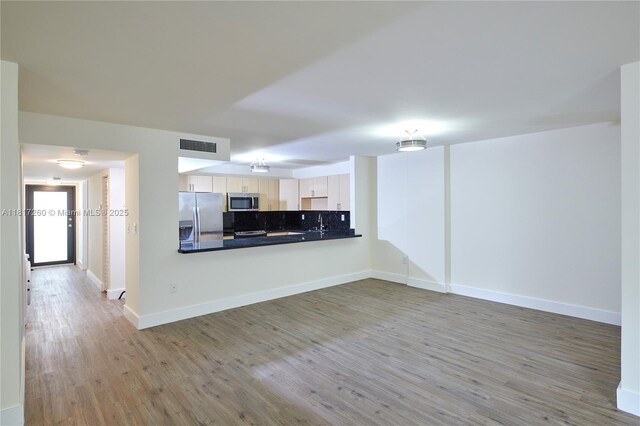 5845 Collins Ave Unit 304, Miami Beach, FL 33140 - unfurnished living room with wood finished floors and baseboards