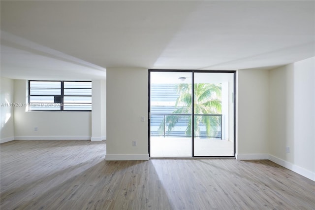 5845 Collins Ave Unit 304, Miami Beach, FL 33140 - unfurnished room featuring wood finished floors, plenty of natural light, baseboards, and expansive windows