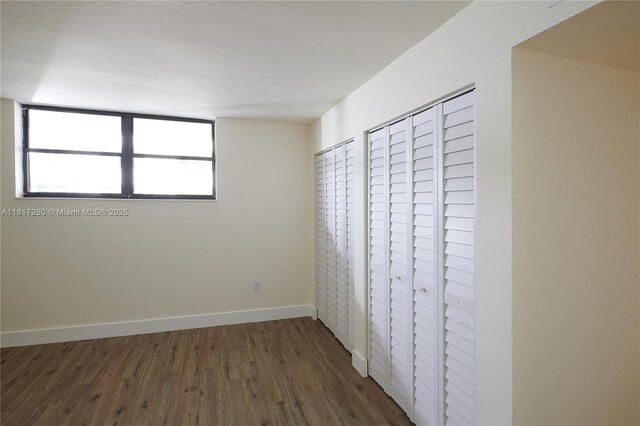 5845 Collins Ave Unit 304, Miami Beach, FL 33140 - unfurnished bedroom with dark wood-type flooring and baseboards