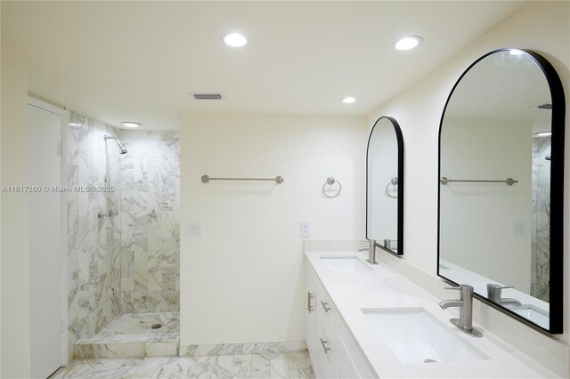 5845 Collins Ave Unit 304, Miami Beach, FL 33140 - bathroom featuring marble look tiles, recessed lighting, double vanity, a marble finish shower, and baseboards